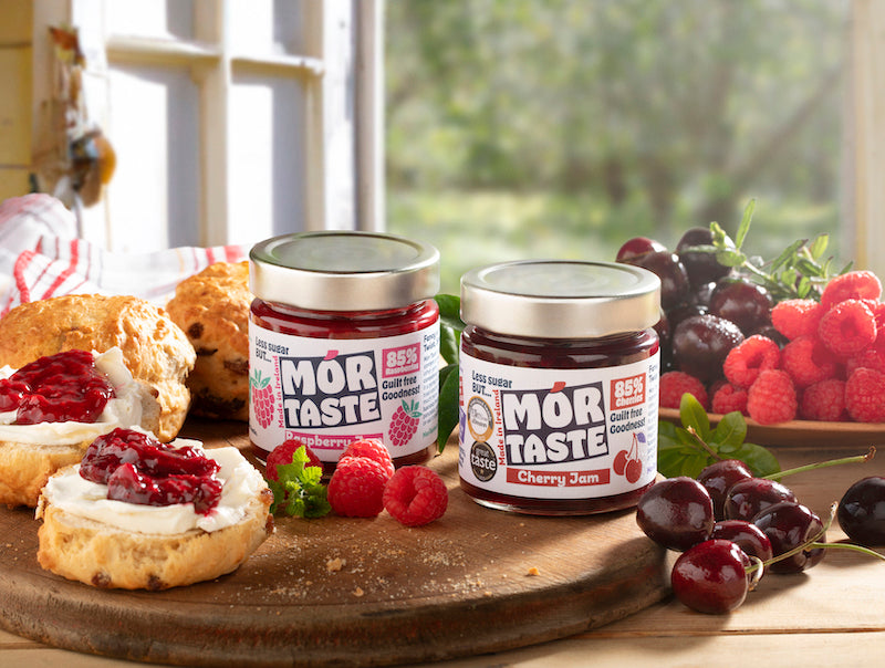 Mór Taste jams on a wooden board with scones and fresh fruit